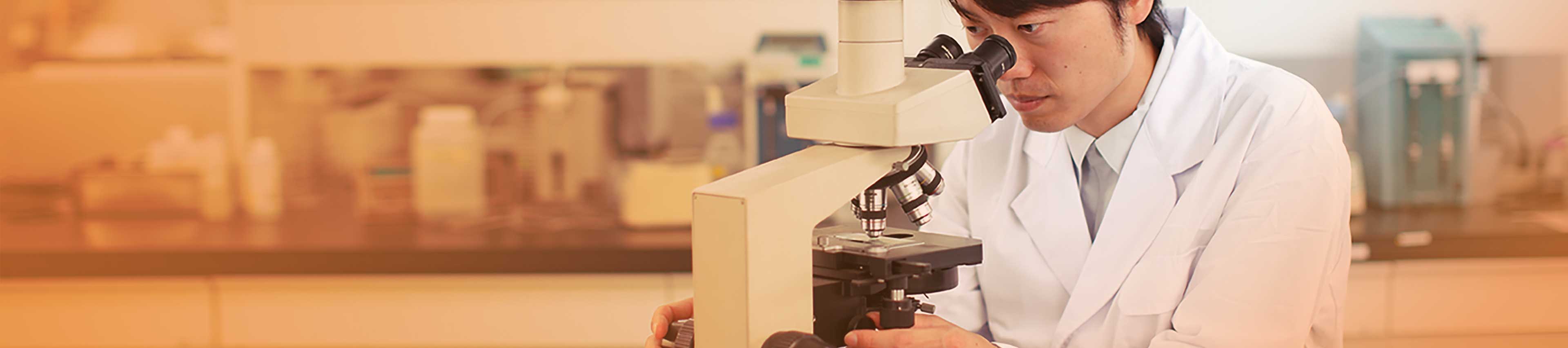 Researcher examining a sample through a microscope